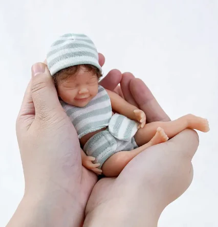 Śpiąca uśmiechnięta mini lalka reborn