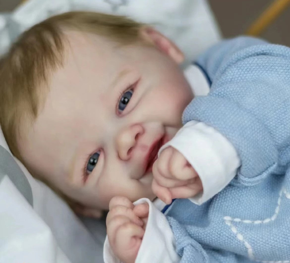 Uśmiechnięta lalki reborn z blond włosami